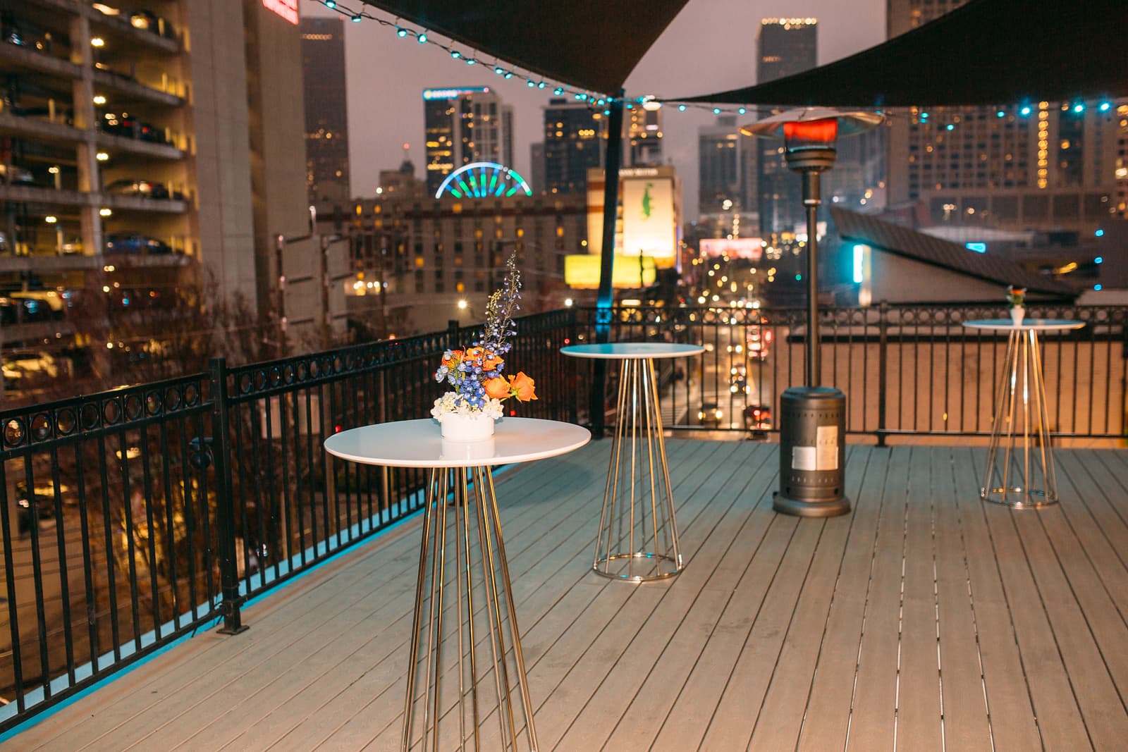 Rooftop Terrace cocktail tables at dusk with SkyView Ferris wheel beyond