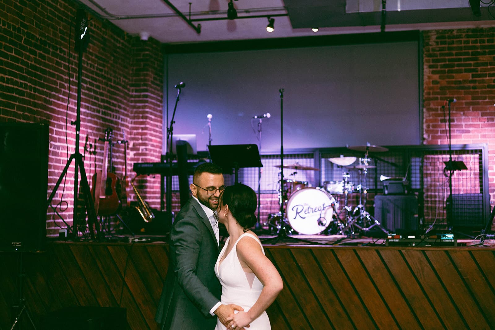 Bride and groom dancing in front of stage