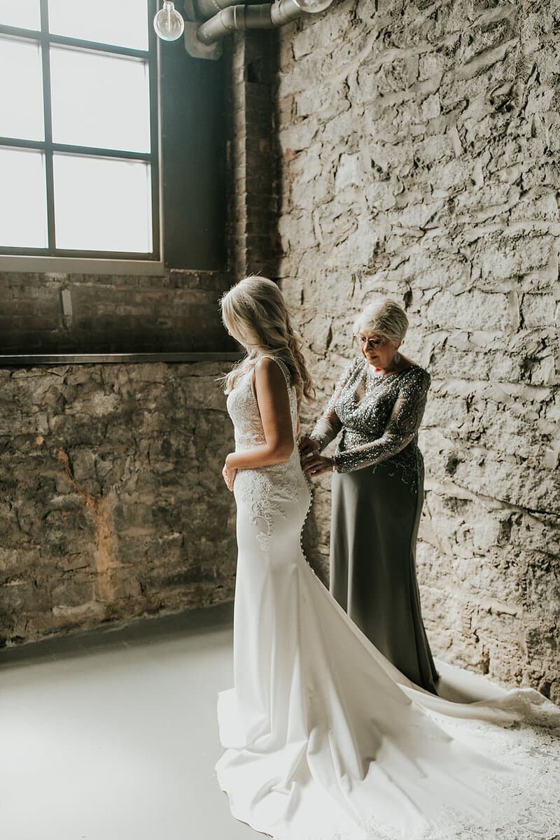 Grandmother checking bride's dress in the Cellar