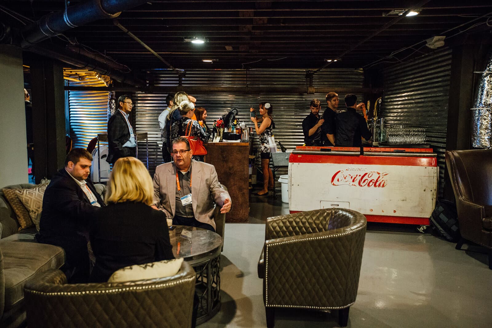People gathered around vintage Coke fridge in the Cellar