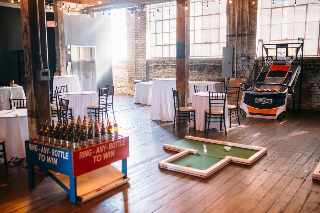 Ring toss, mini golf, and arcade basketball game stations indoors
