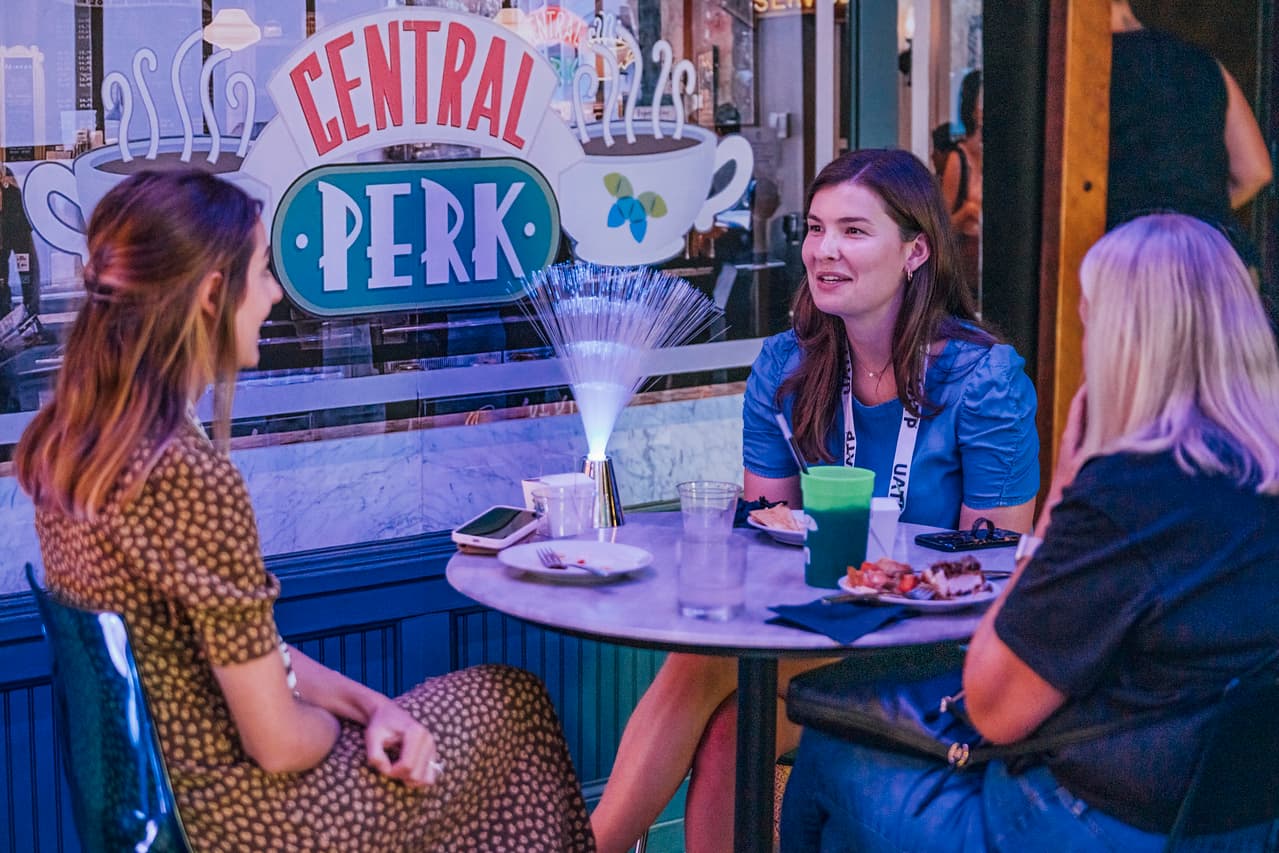 Guests chatting at a Friends-themed Central Perk cafe backdrop