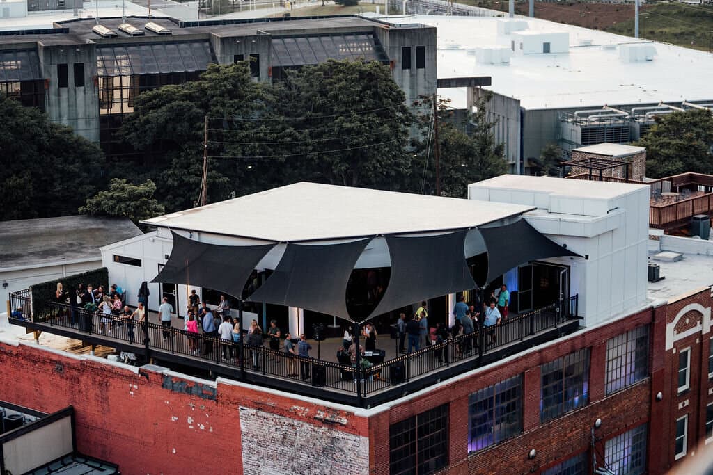 Drone shot of people enjoying drinks on the rooftop