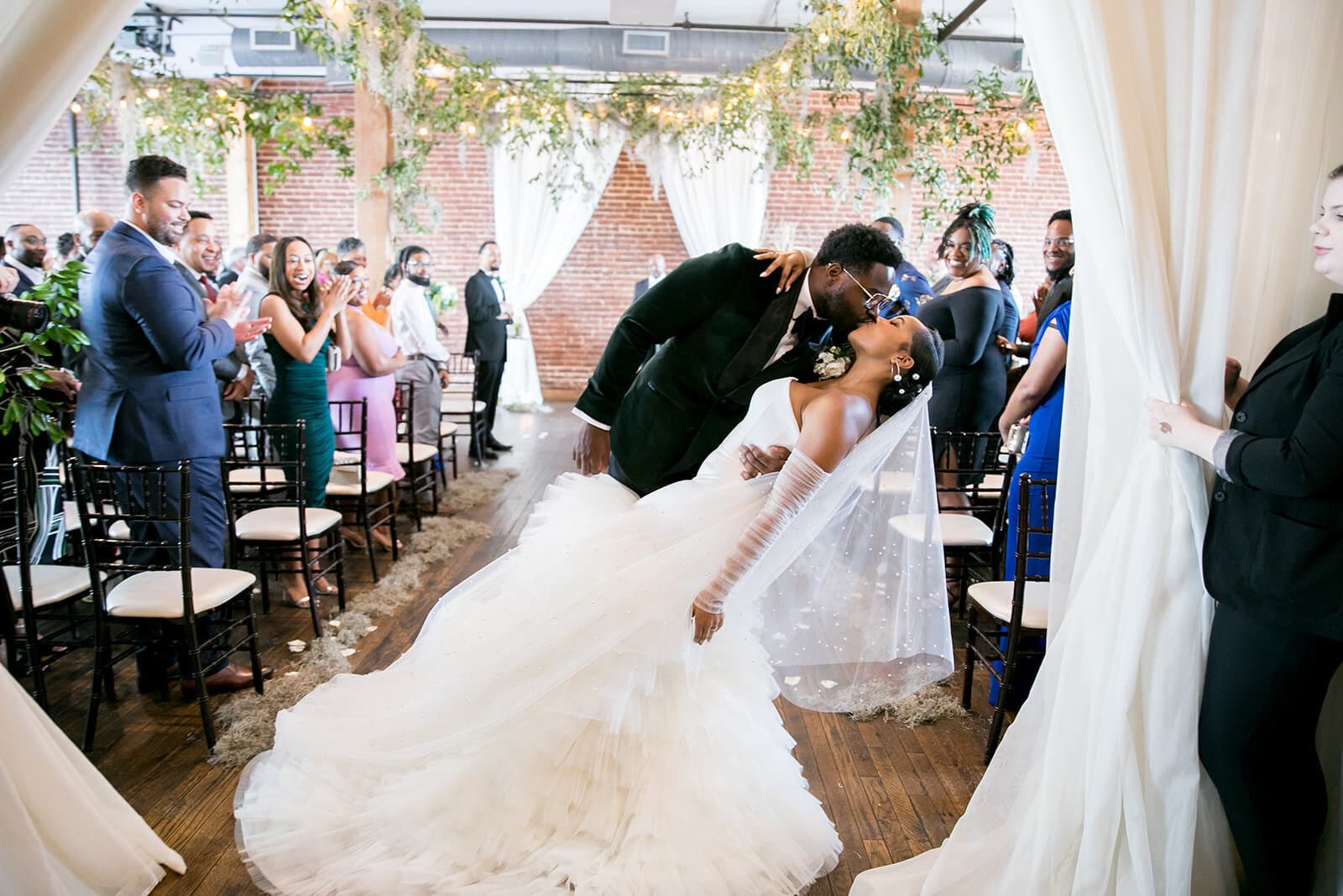 Bride and groom kissing in aisle